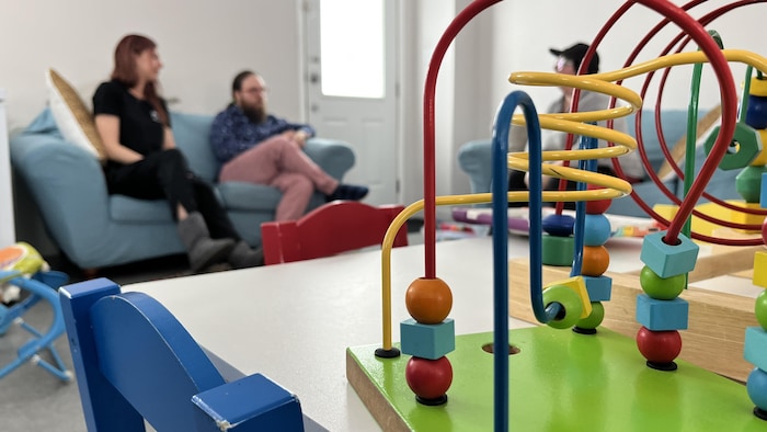 Un jeu pour enfant avec des parents assis plus loin en arrière-plan.