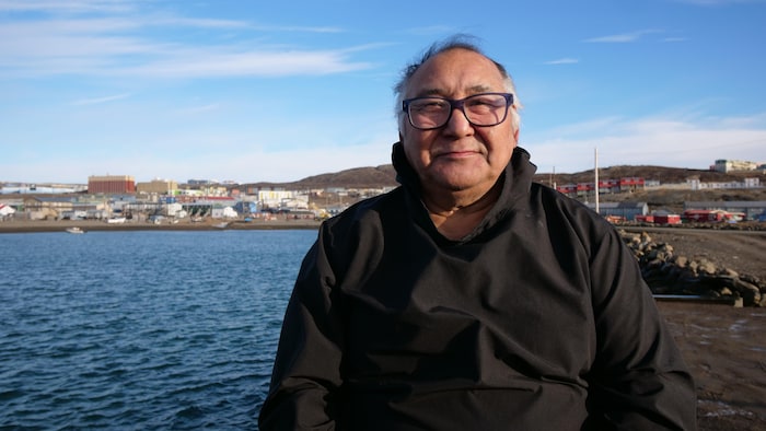 Un homme devant une vue d'Iqaluit.