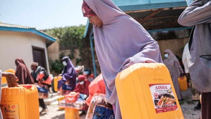 Une femme tient dans ses mains des paquets distribuées par une organisation.