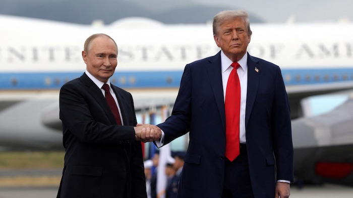 Trump et Poutine se serrent la main sur le tarmac.