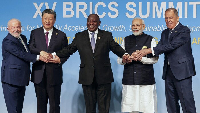 Luiz Inacio Lula da Silva, Xi Jinping, Cyril Ramaphosa, Narendra Modi et Sergei Lavrov se serrent la main sur scène lors du sommet du BRICS.