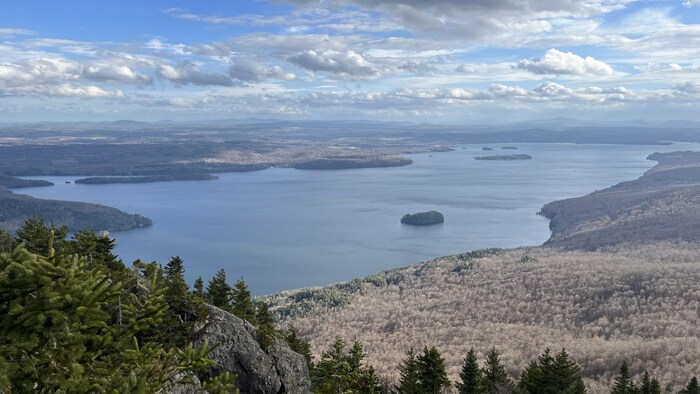 Vue en plongée sur un lac parsemé d'îles, entouré d'une forêt dont les arbres sont dépouillés de leurs feuilles.