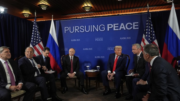 Donald Trump, Vladimir Poutine et leurs conseillers respectifs sont assis dans une salle de réunion en Alaska, le 15 août 2025.