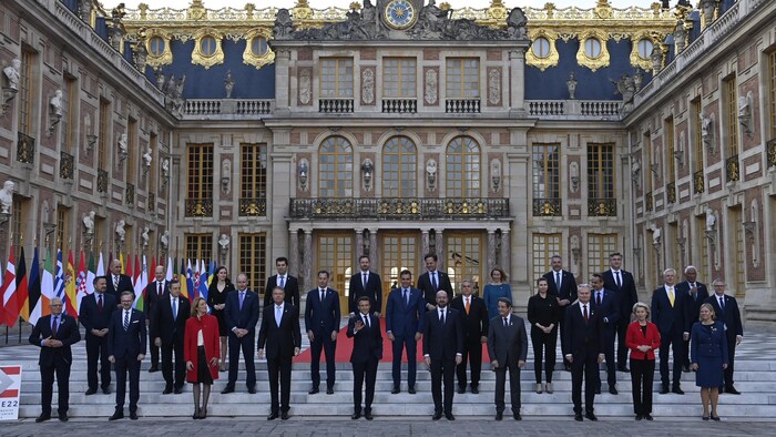 Portrait d'hommes et de femmes devant un château.