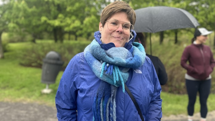 Près d'autres participants à une marche, Sonia Laterreur Léon sourit à la caméra.