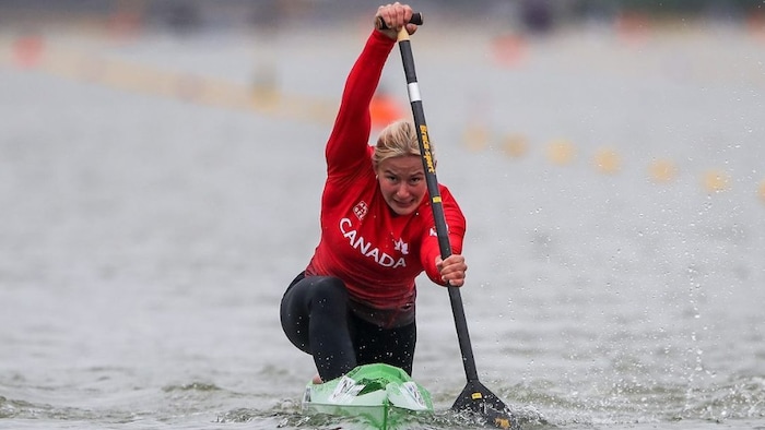 She is wearing a uniform in Canada's colors as she rows.