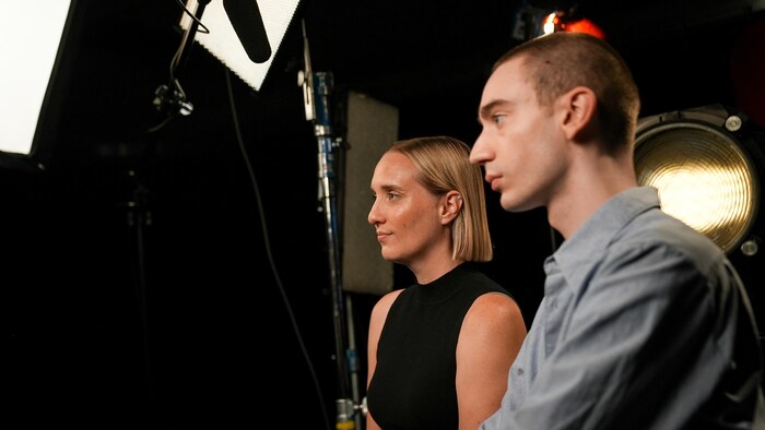 Deux personnes de profil sous des projecteurs.