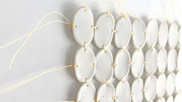 Cercles de porcelaine tissés avec des fils de coton orange.