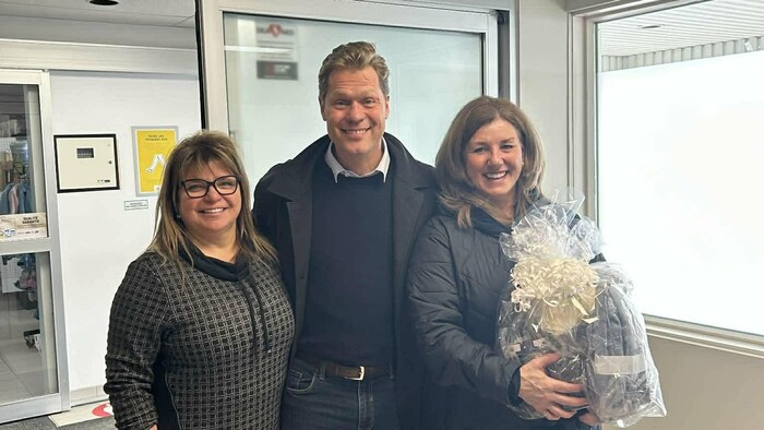 Sonia Daraiche tient des fleurs, à côté d'Alexis Deschênes et de la mairesse, Annie Bélanger.