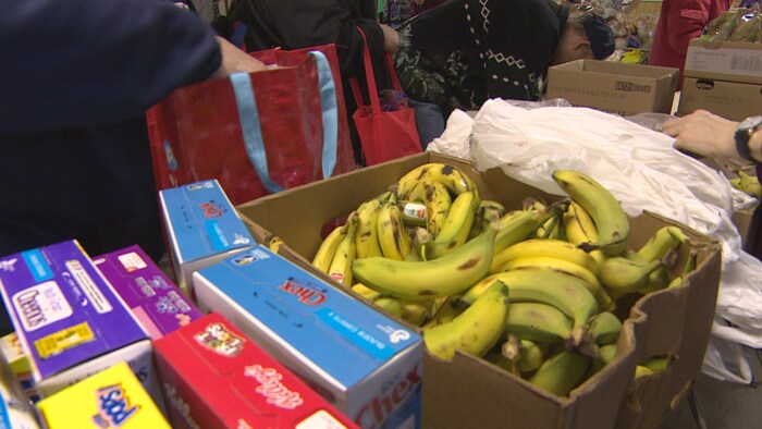 Photo d'un panier avec plein de bananes et de boîtes de céréales. 