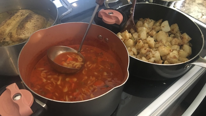 Un chaudron de soupe et un chaudron de pommes de terre sur une cuisinière.