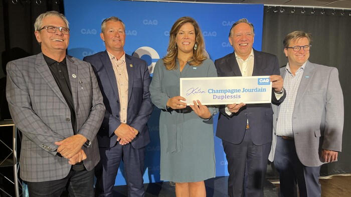 Le maire de Port-Cartier, Alain Thibault, le maire de Sept-Îles, Steeve Baupré, et le candidat de la CAQ dans la circonscription de René-Lévesque, Yves Montigny, Kateri Champagne Jourdain et François Legault souriant.