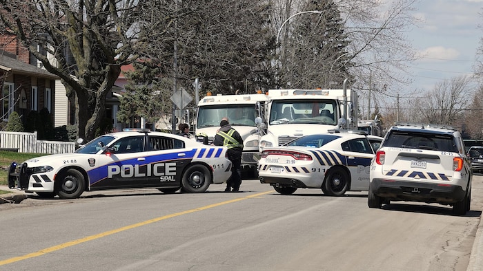 Des véhicules d'urgence sur une rue résidentielle.