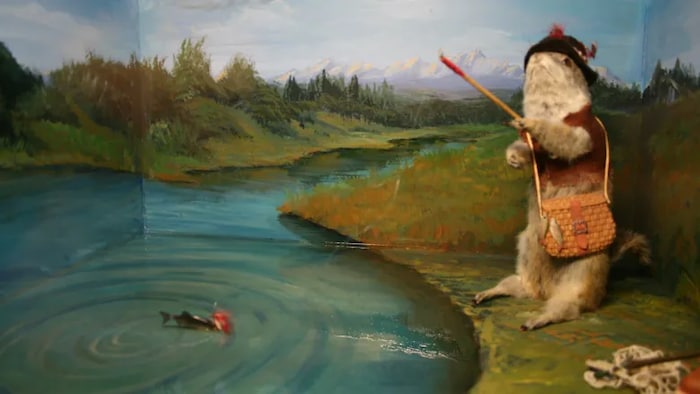 Une toile présentant un rongeur habillé en humain et s’adonnant à la pêche à la ligne.