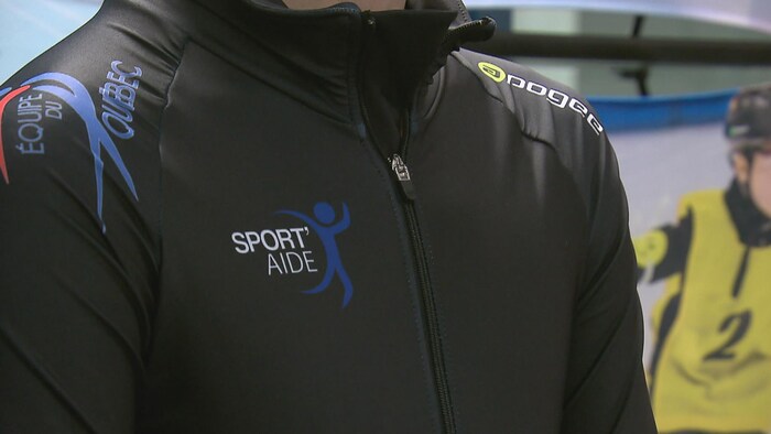Un patineur arbore le logo de Sport’Aide sur son uniforme de l’Équipe du Québec.