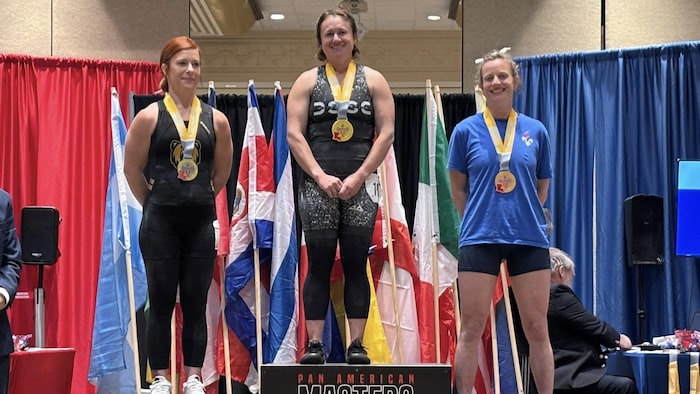 Émilie Auclair se tient sur la troisième marche d'un podium, médaille au cou.