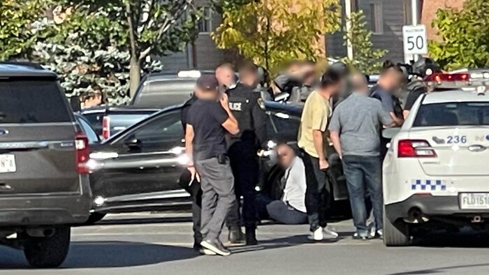 Un homme assis au sol a été arrêté par les policiers.