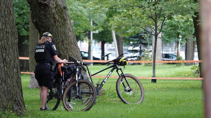 Une policière à vélo à côté d'un périmètre de sécurité