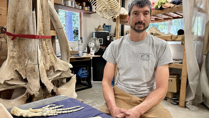 Mike deRoos dans son atelier, entouré de squelettes.