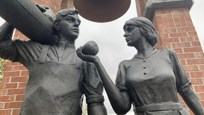 Deux statues représentant un homme et une femme qui travaillaient à l'usine.