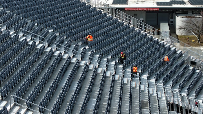 Des travailleurs de la construction s’affairent dans les gradins temporaires du stade BMO le 24 mars 2026.