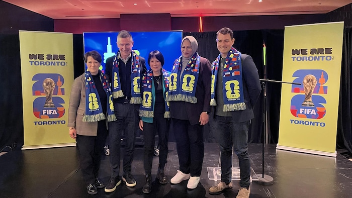 Des hommes et des femmes debout sur un estrade 
