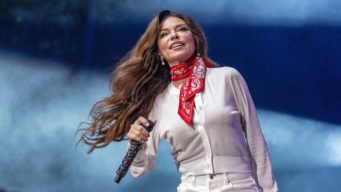 Shania Twain tenant un micro.