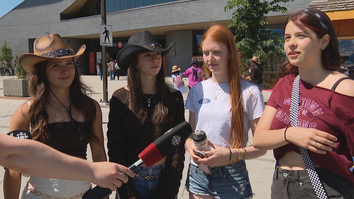 Quatre jeunes femmes participent à une entrevue à l'extérieur lors du Stampede.