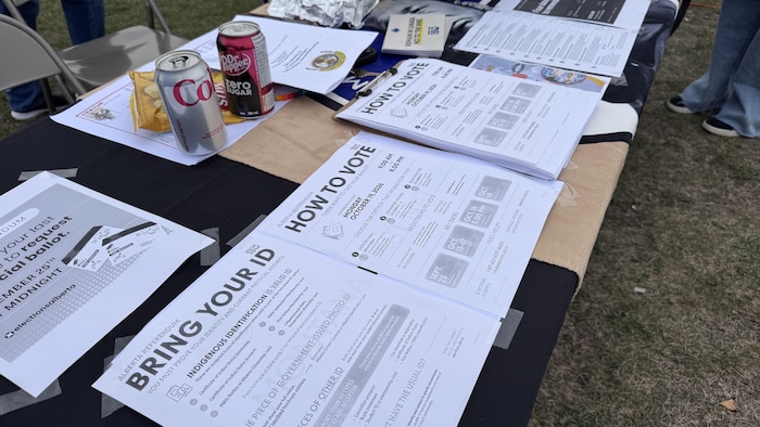 Des brochures étalées sur une table indiquent la procédure pour aller voter.