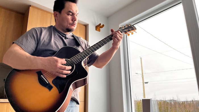 Portrait de Johnny Saunders avec sa guitare. 