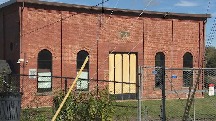 Un bâtiment en brique rouge avec des fenêtres en arc.