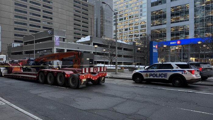 Un stationnement recouvert de neige avec la police devant.