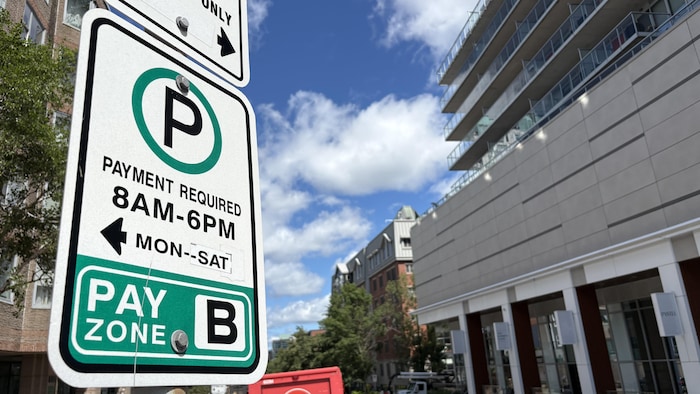 Un panneau de stationnement de la zone B où un collant a été apposé pour dire qu'il est payant jusqu'au samedi.