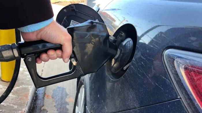 Une personne met de l'essence dans sa voiture.