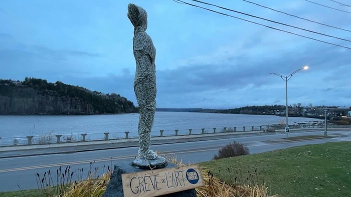 Une statue est recouverte d'un expansive tissu.