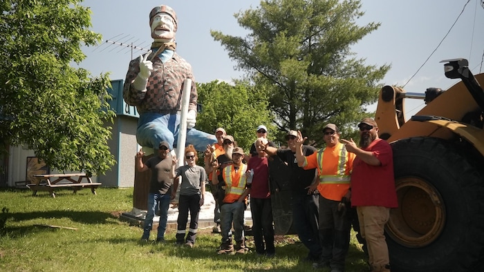 L'équipe de transport devant la statue du bûcheron.
