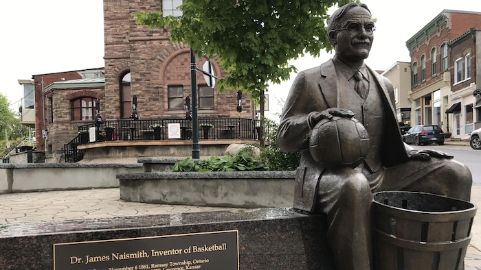 Estatua de bronce con una placa conmemorativa de James Naismith, el inventor del baloncesto.