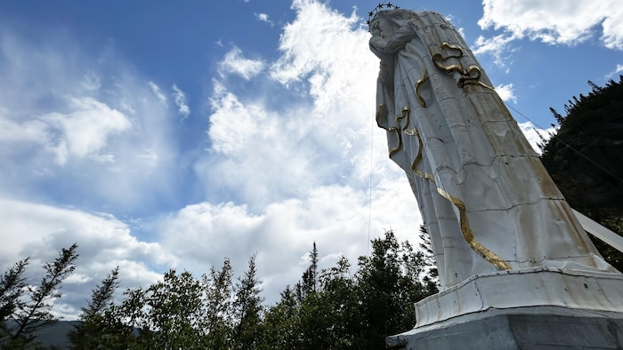 Une statue de la Vierge est située en montagne.