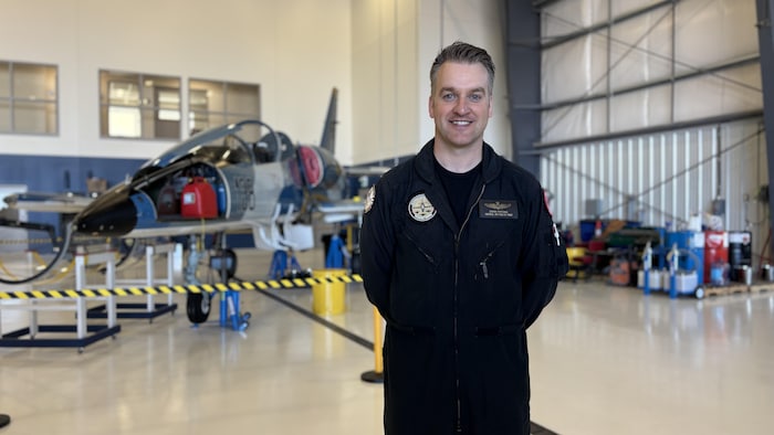 Portrait de Stefan Porteous devant un avion.