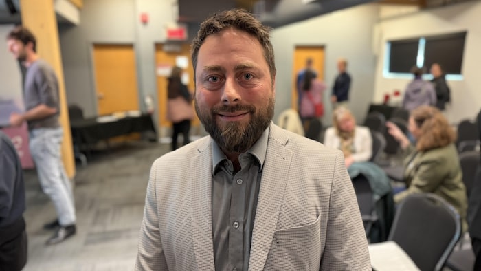 Stéphane Brown sourit pour la photo après une conférence.