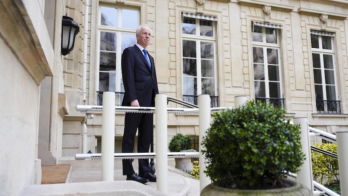 Un homme sur le perron d'une résidence officielle.