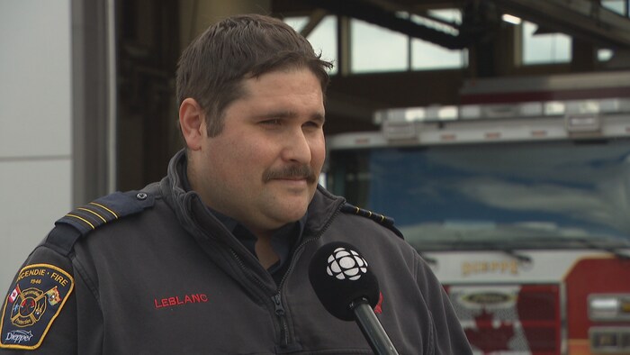 Stephane LeBlanc devant un camion de pompier.
