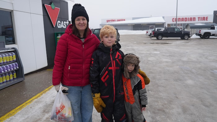 Stephanie et ses deux enfants devant une station d'essence.