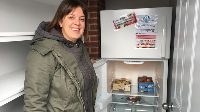 A woman in front of a community refrigerator in Baie-Comeau new parental union regime: necessary, new parental union regime: necessary, new