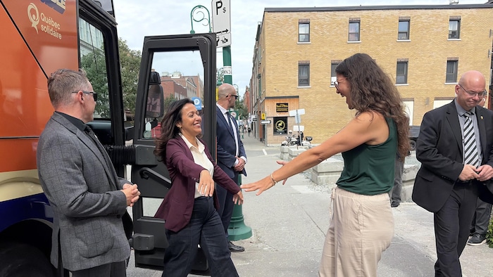 Ruba Ghazal regarde Stéphanie Vachon en souriant en sortant de l'autobus de campagne.