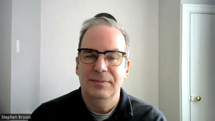 Stephen Brown porte des lunettes et est en entrevue.