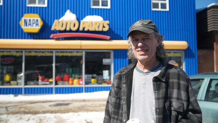 Stephen Martel devant un garage.
