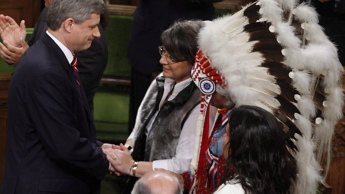 M. Harper serre la main de Mme Simon.