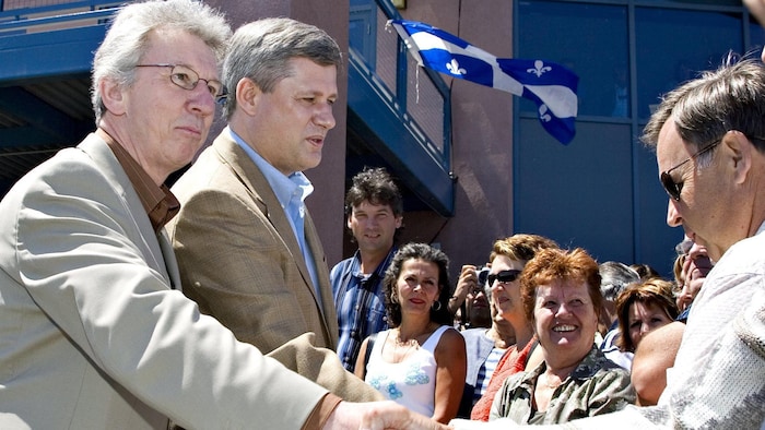 Le premier ministre Stephen Harper et le ministre du Travail Jean-Pierre Blackburn saluent la foule lors d'une célébration de la Fête nationale du Québec à Roberval, au Québec, le dimanche 24 juin 2007.