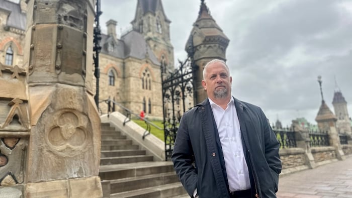 Il pose à l'extérieur du parlement.